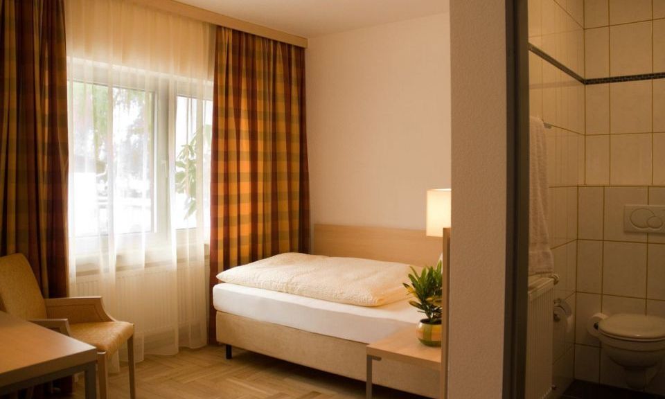 Einzelzimmer im Gaestehaus Birkenhof was die  Dependance des Weinhotel Kaisergarten darstellt hier Blick auf das Bett und in das Badezimmer